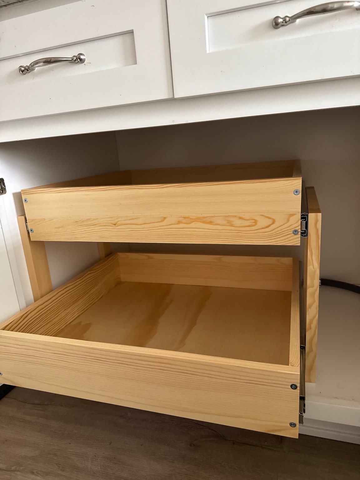 Wooden pull-out storage drawers fitted inside a white cabinet
